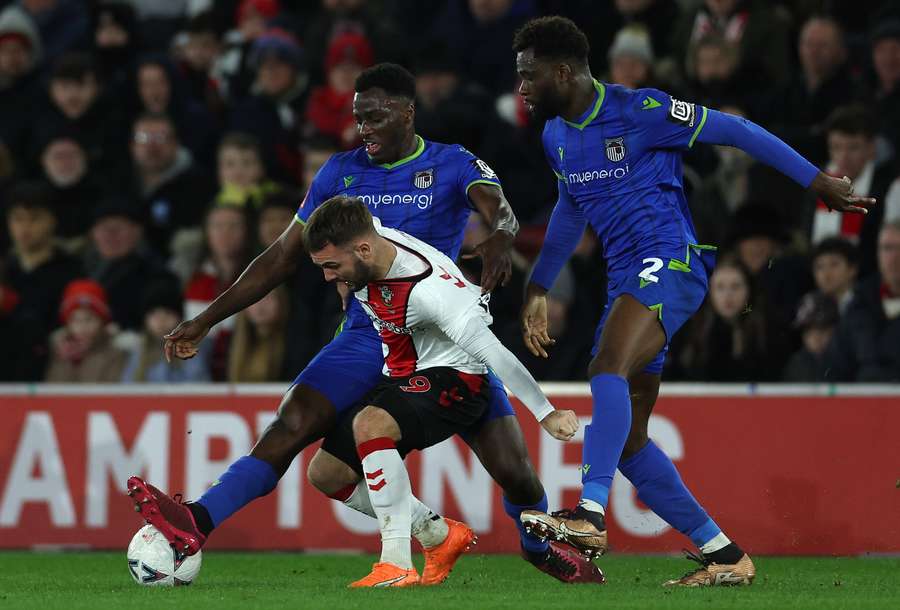 Grimsby's forward Jordan Maguire-Drew and defender Michee Efete vie with Southampton's striker Adam Armstrong