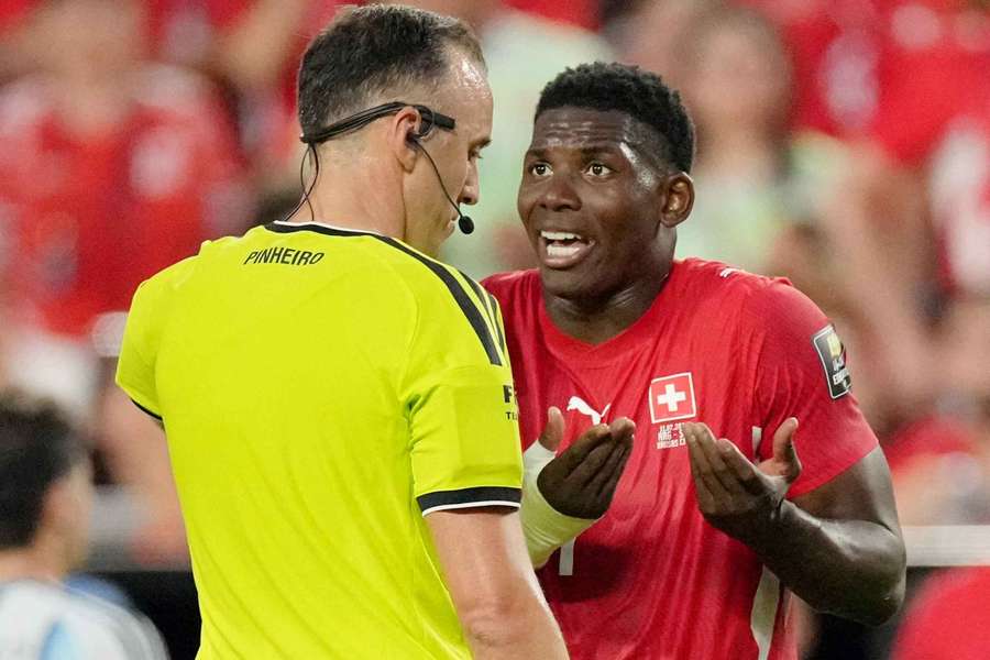Breel Embolo remonstrates with Joao Pinheiro after being sent off for Switzerland