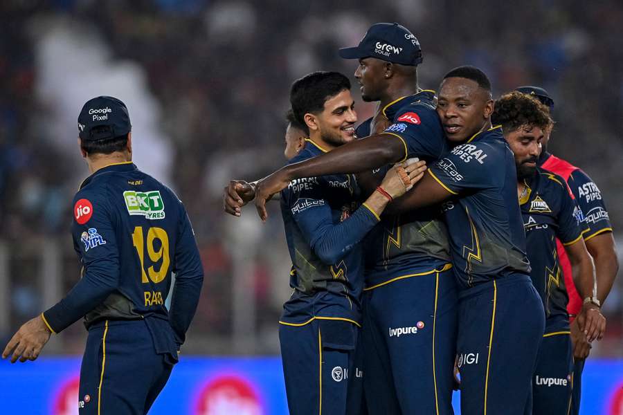Jason Holder is mobbed by teammates after helping secure victory for Gujarat