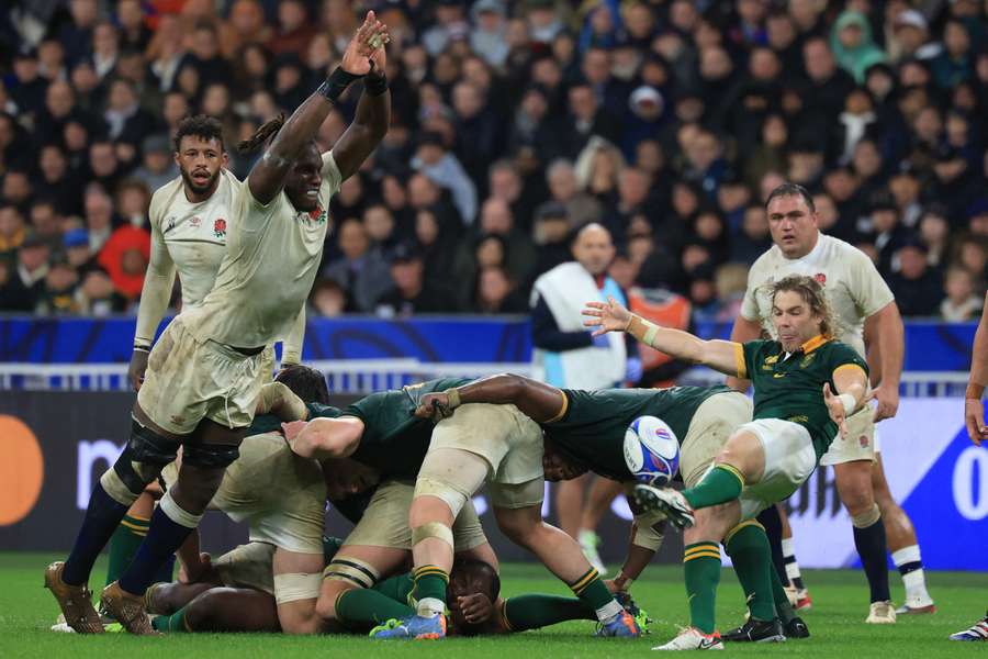 South Africa's scrum-half Faf de Klerk (R) kicks the ball as England's lock Maro Itoje (2nd L) attempts a run down