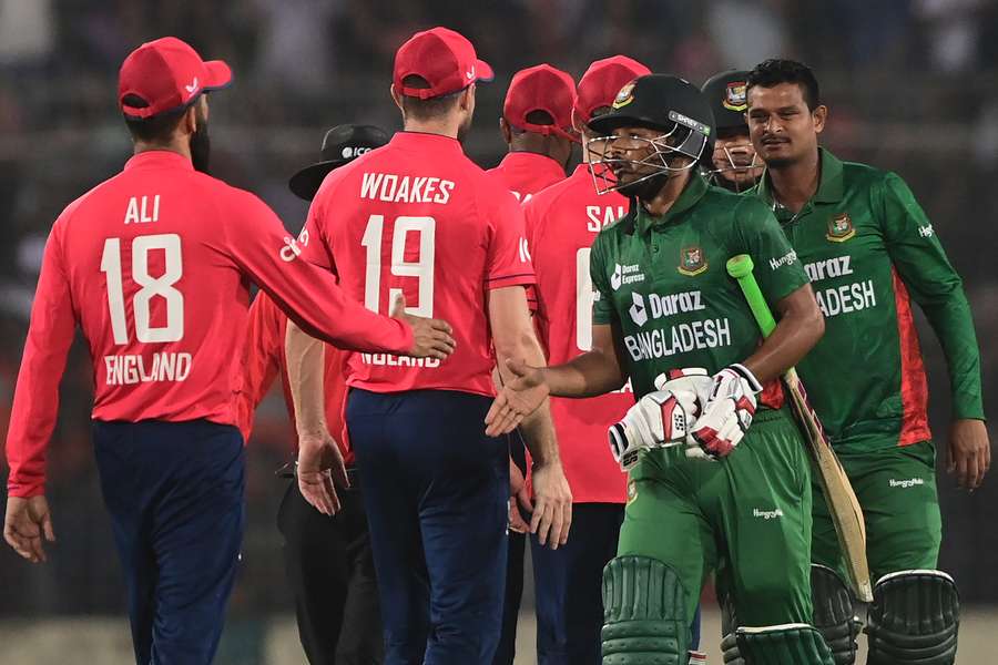 Bangladesh's (R) and England's players greet each other at the end of the match