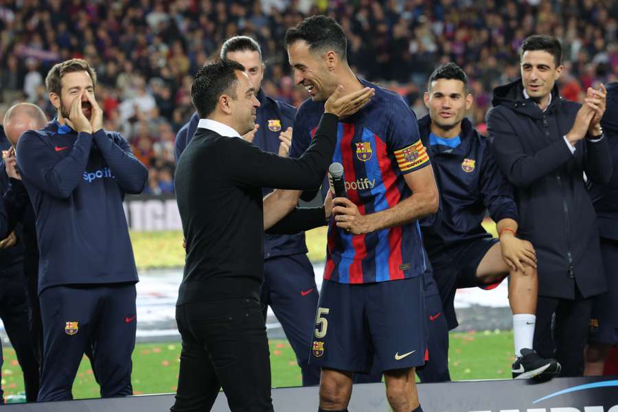 Xavi (L) embraces Busquets