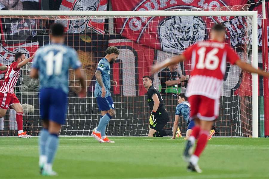 Il portiere dell'Aston Villa Emiliano Martinez siede sconsolato dopo che Ayoub El Kaabi dell'Olympiacos ha segnato il primo gol della sua squadra.