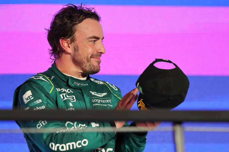 Aston Martin's Spanish driver Fernando Alonso reacts on the podium