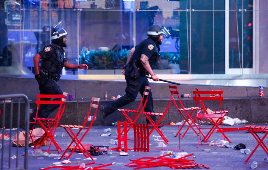Policias correm pela Times Square após tiros serem disparados no local
