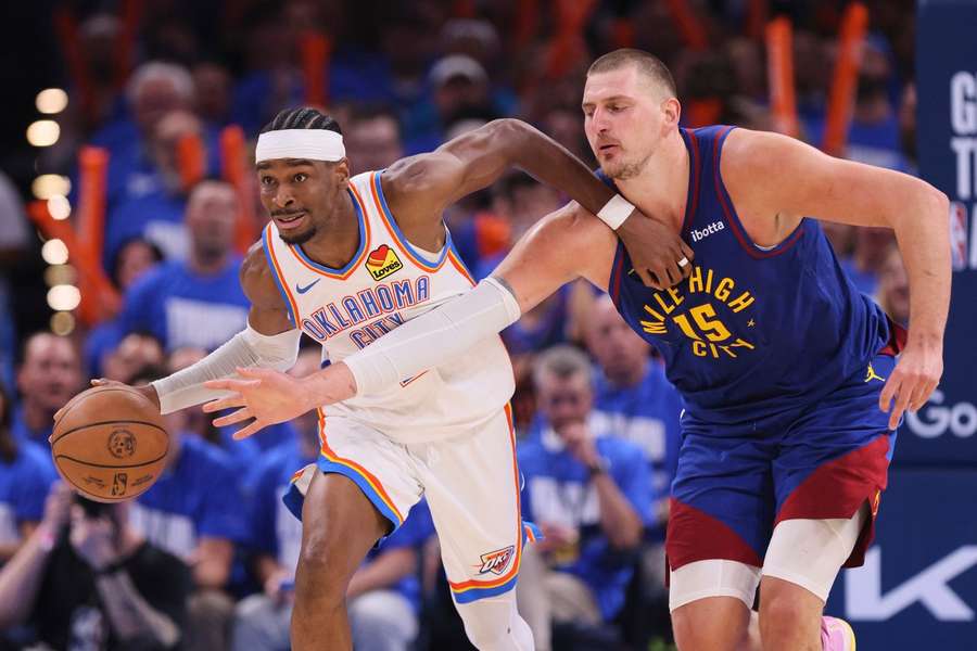 Oklahoma City Thunder's Shai Gilgeous-Alexander advances the ball upcourt under pressure from Denver Nuggets' Nikola Jokic