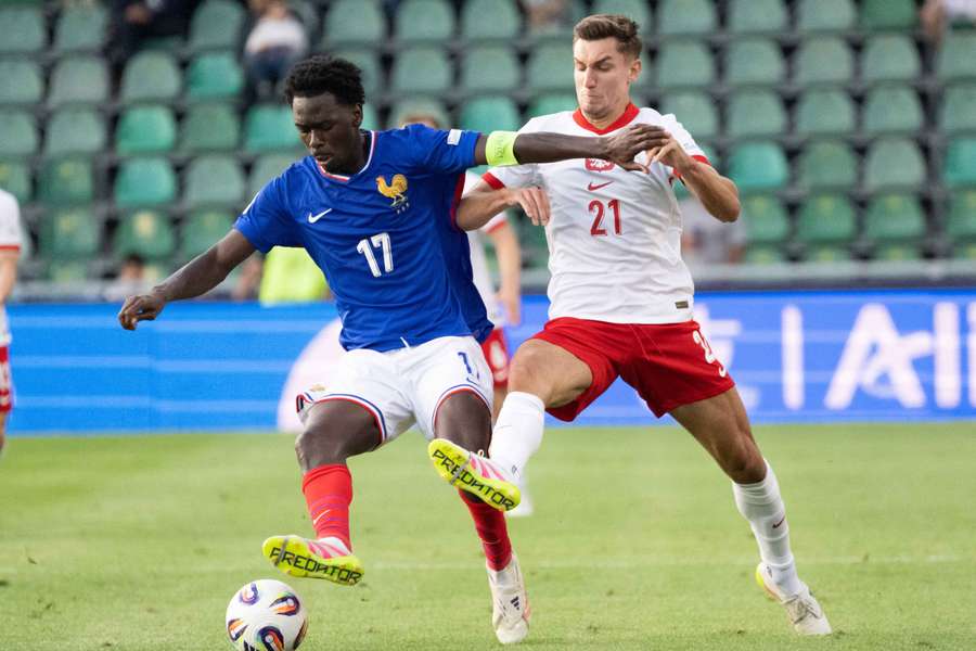 Soungoutou Magassa (L) i Tomasz Pienko walczą o piłkę podczas meczu Mistrzostw Europy UEFA U21 w grupie C.
