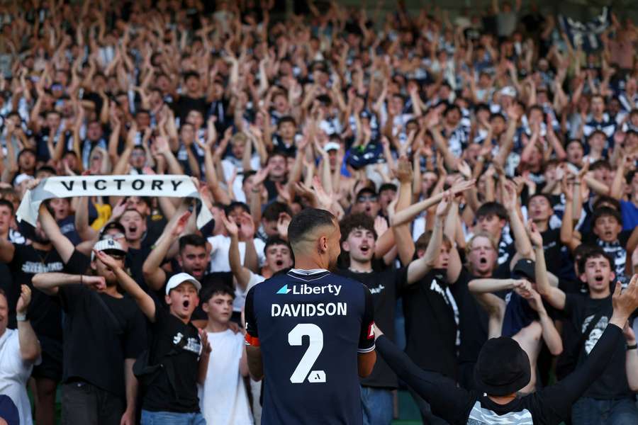 Melbourne Victory fullback Jason Davidson celebrates their Big Blue victory with the Northern Terrace.