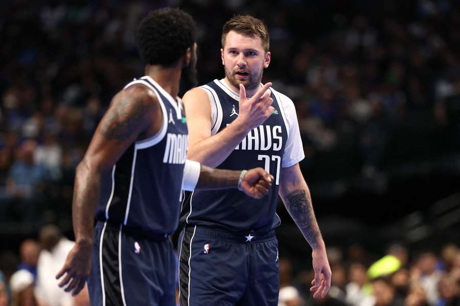 Luka Doncic conversa con Kyrie Irving