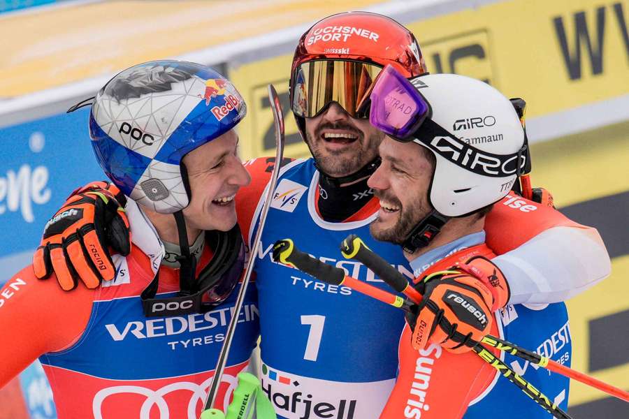 Marco Odermatt (l) celebrates with Swiss team-mates Loic Meillard (c) and Thomas Tumler