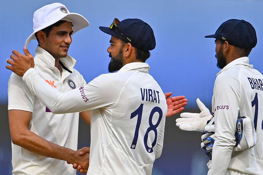 India's Shubman Gill (L) is greeted by his teammate Virat Kohli (C) as Srikar Bharat watches