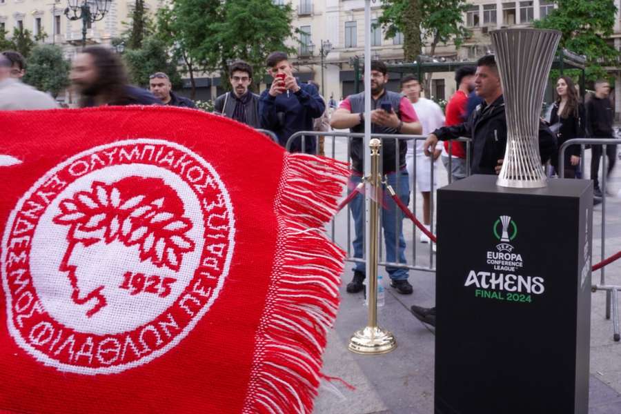Cachecol do Olympiacos ao lado do troféu da Liga Conferência em Atenas