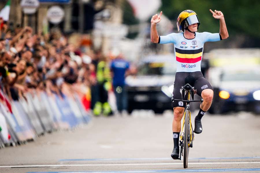 Remco Evenepoel celebrates as he crosses the finish line to win the men's elite time trial race at the 2024 UCI Road World Championships