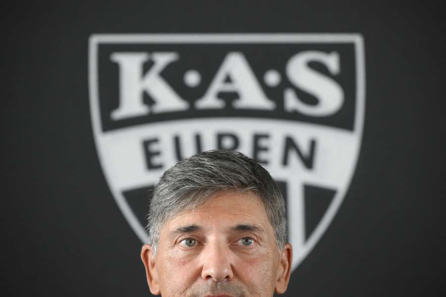 Le coach d'Eupen et le logo du club derrière lui (juillet 2026). Le coach d'Eupen et le logo du club derrière lui (juillet 2026).