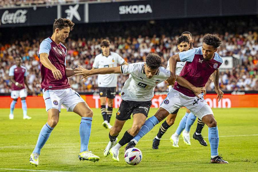 El joven Fran Pérez intenta llevarse el balón entre dos jugadores del Aston Villa. 