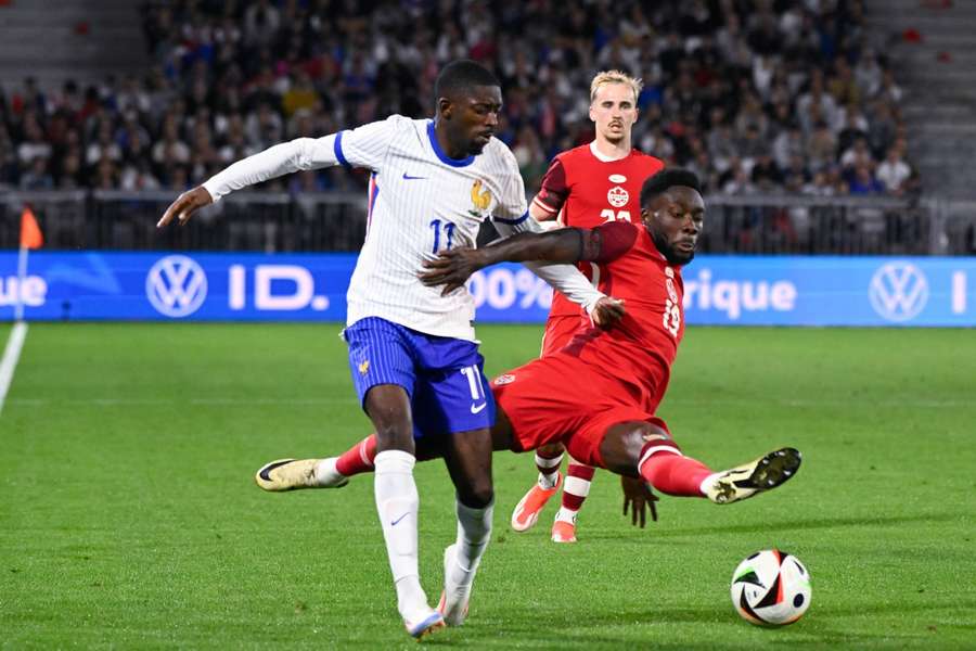 Ousmane Dembele of France and Alphonso Davies of Canada battle for the ball