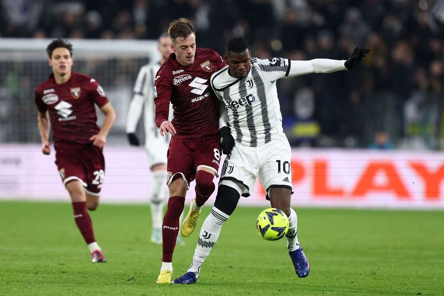 Paul Pogba in duel met Ivan Ilic (R)