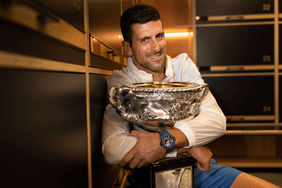 Srbský tenista Novak Djokovič pózuje v šatni s trofejou po výhre na Australian Open 2023.