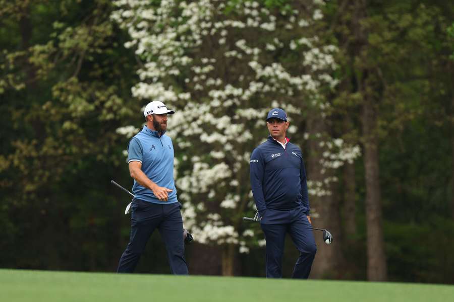 Gary Woodland and Dustin Johnson of the United States walk up the 11th fairway during a practice round