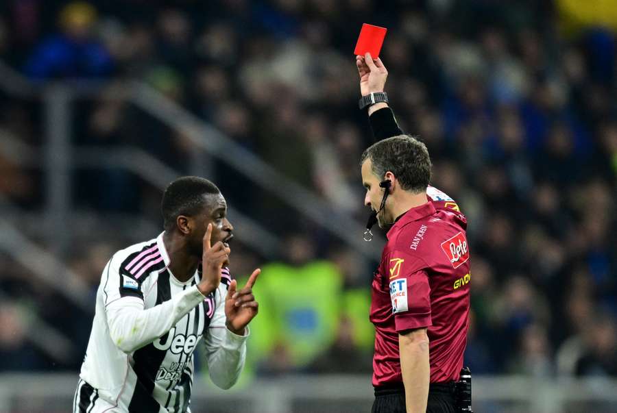 Juventus' Pierre Kalulu is shown a red card by referee Federico La Penna