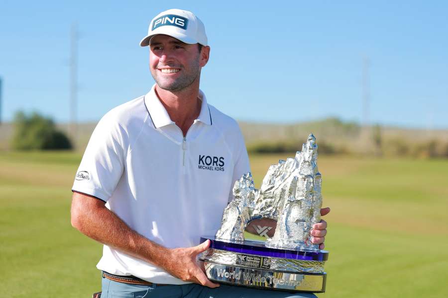 Austin Eckroat poses with the championship trophy