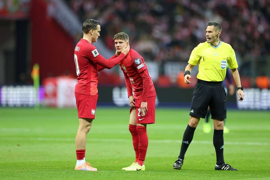 Piotr Zieliński pociesza kontuzjowanego Sebastiana Szymańskiego poczas meczu Polski z Holandią w Warszawie. Piotr Zieliński pociesza kontuzjowanego Sebastiana Szymańskiego poczas meczu Polski z Holandią w Warszawie.