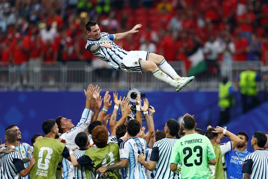 Lionel Messi nad hlavami spoluhráčů po postupu do čtvrtfinále MS.
