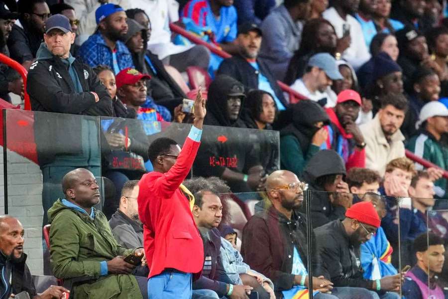 "Lumumba Vea" steht regungslos auf der Tribüne.