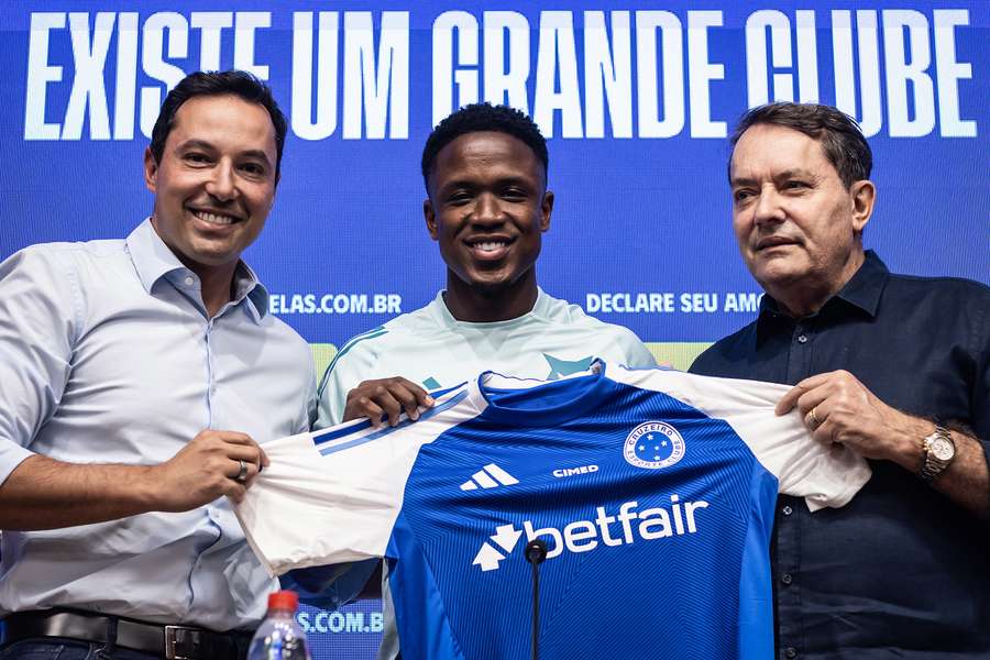 Sinisterra recebe camisa das mãos de Pedrinho, dono da SAF do Cruzeiro, e Pedro Junio, responsável pelo futebol celeste
