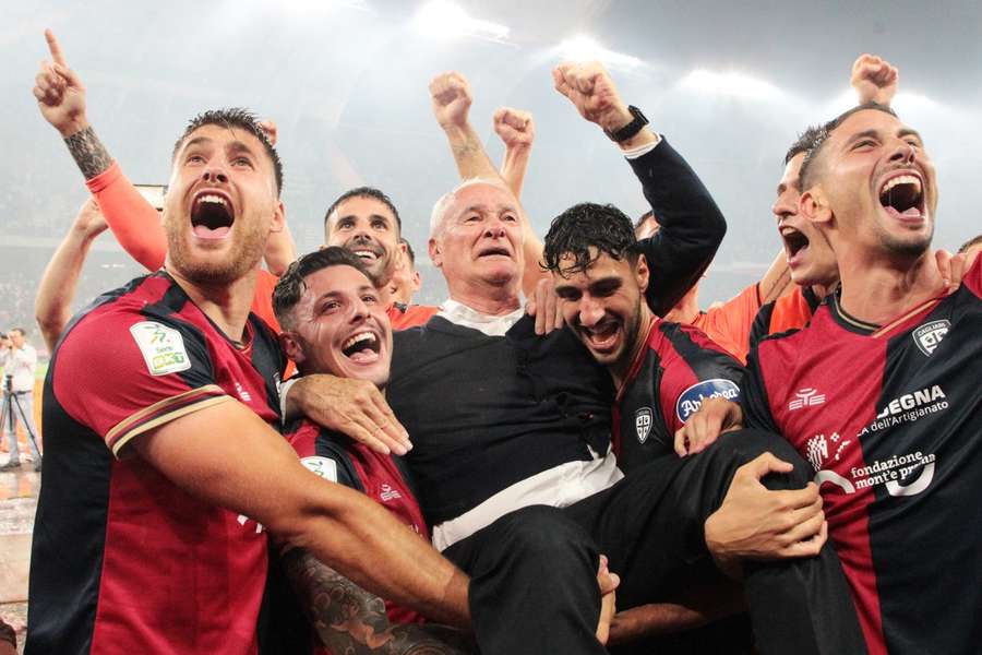 Cagliari's players lift manager Claudio Ranieri in celebration