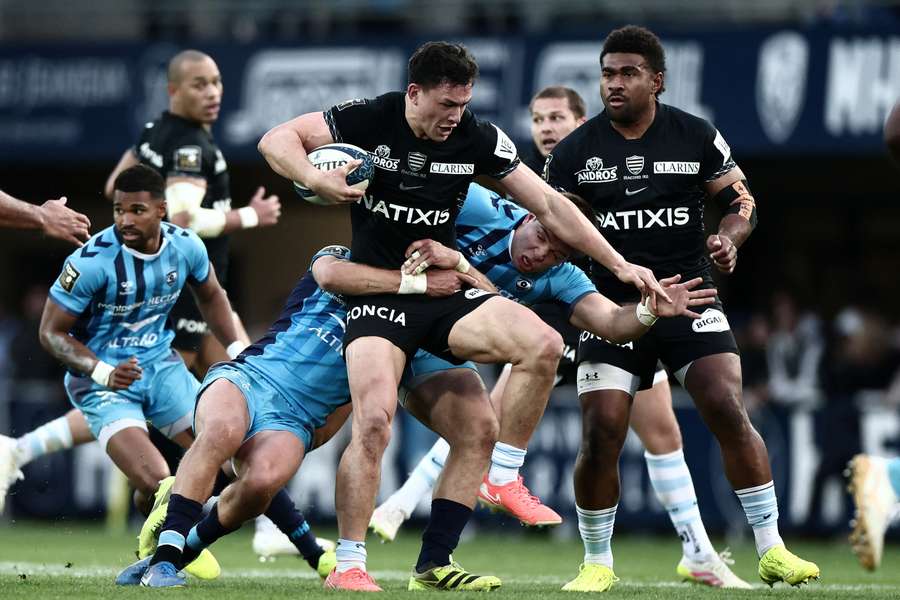 Manu attempts to evade a tackle in a French Top 14 union game between Racing 92 and Montpellier.