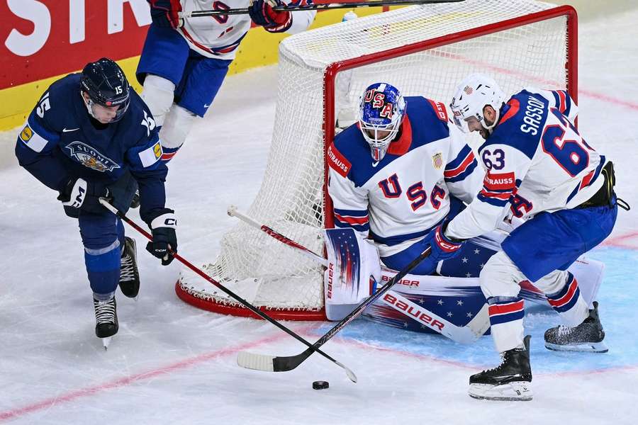 Finland's Anton Lundell (L) fights for the puck with USA's Max Sasson