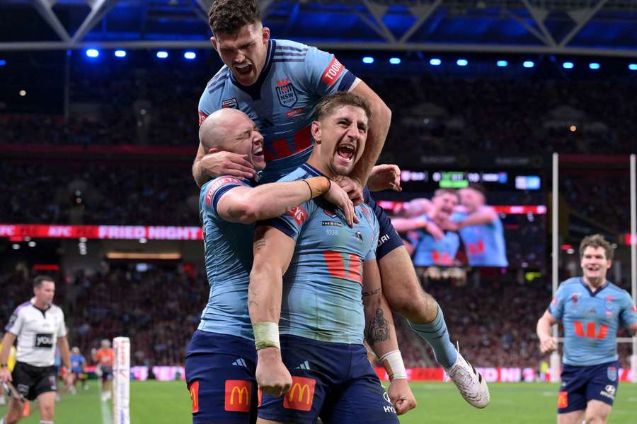 Zac Lomax is mobbed by team-mates after scoring