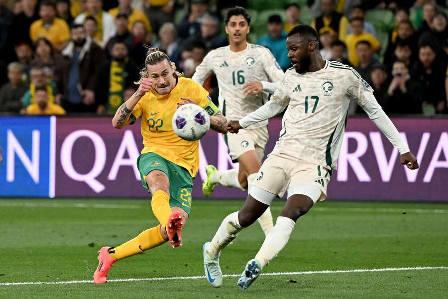 Australia’s Jackson Irvine (left) shoots for goal next to Saudi Arabia’s Hassan Al Tambakti