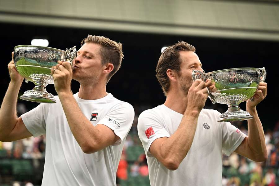 Neal Skupski and Wesley Koolhof lift their trophies on Centre Court