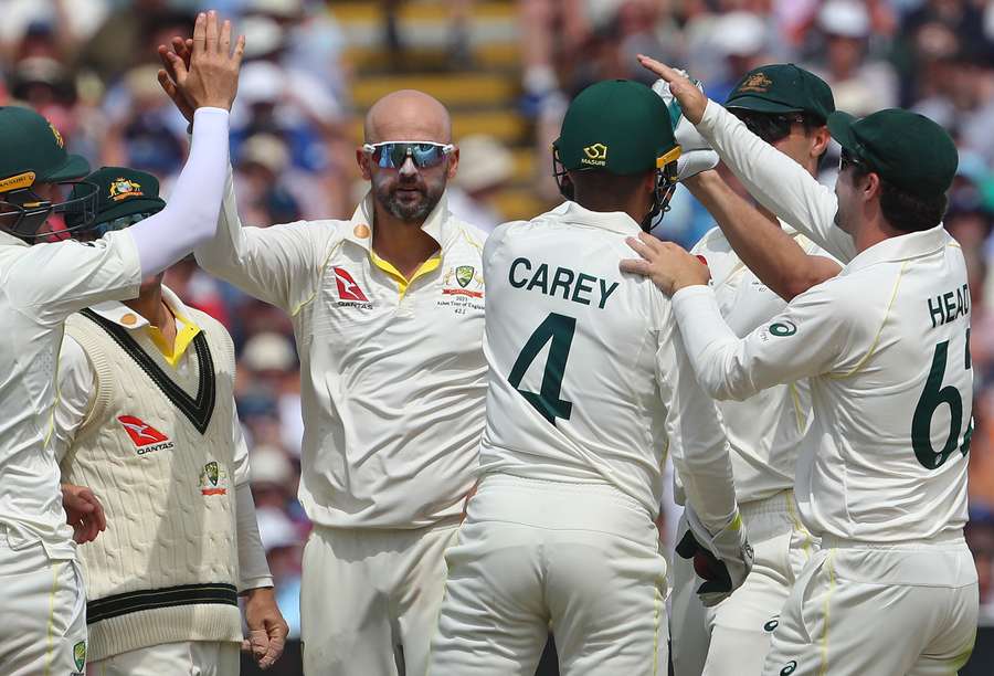 Australia's wicket keeper Alex Carey (3R) and Australia's Nathan Lyon (3L) celebrate with teammates after taking the wicket of England's Joe Root