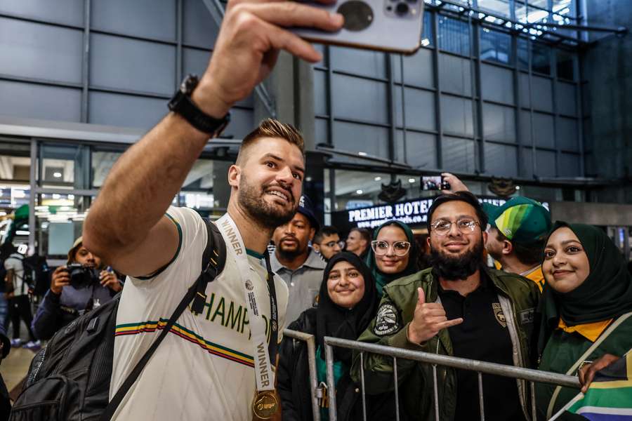 Aiden Markram takes a photograph with fans who were at the airport to welcome the Proteas back to South Africa