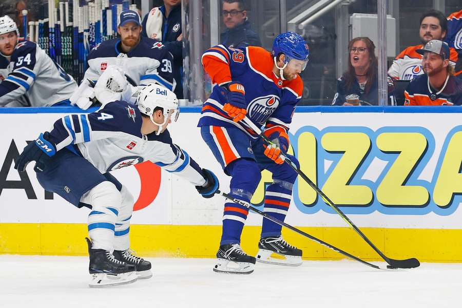 Leon Draisaitl (r.) schützt den Puck gegen Jets-Verteidiger Neal Pionk.