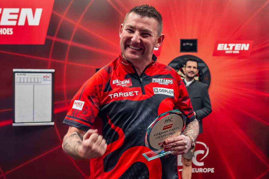 Nathan Aspinall celebrates with the German Darts Grand Prix trophy