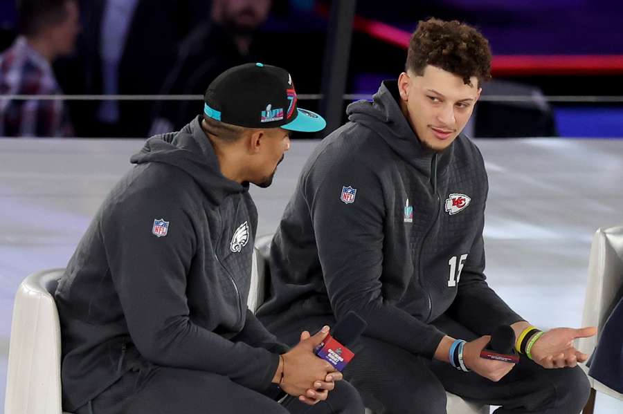 Jalen Hurts y Patrick Mahomes hablan durante la presentación de la Super Bowl LVII.