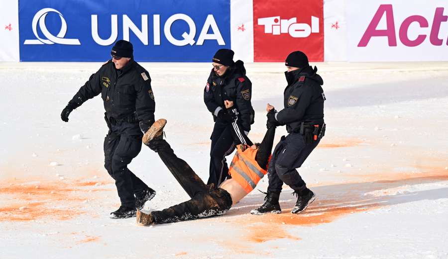 Policemen remove a climate activist from the finish area of the men's Alpine World Cup slalom race in Hochgurgl