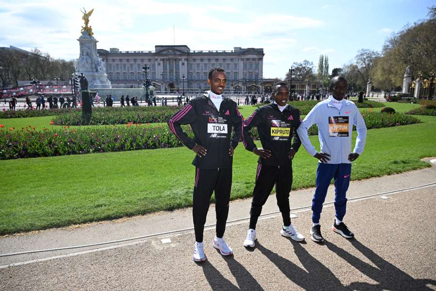 La etíope Tamirat Tola, el keniano Amos Kipruto y el keniano Kelvin Kiptum posan ante el Palacio de Buckingham antes de la carrera.