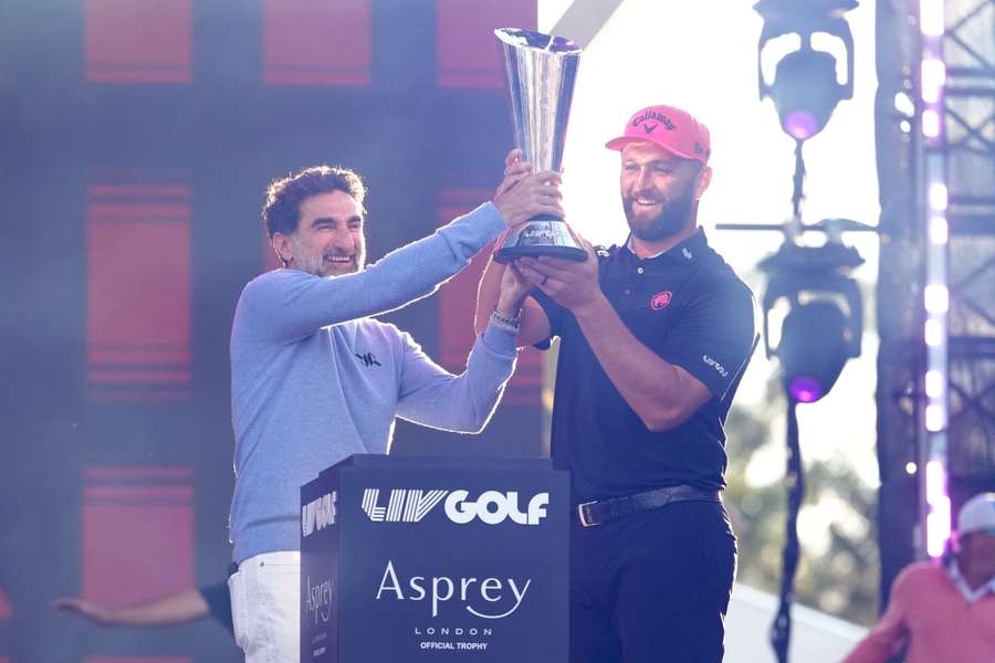 Jon Rahm levanta el trofeo en Michigan junto al presidente de LIV Golf, Yasir Al Rumayyan