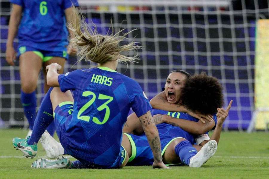 Marta celebrates scoring Brazil's third goal with teammates