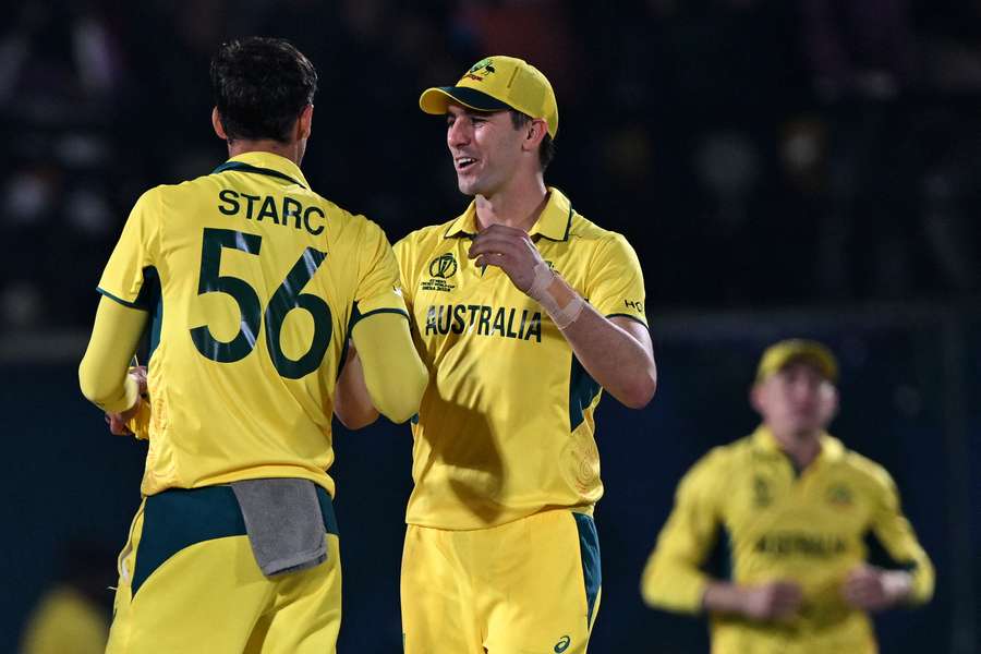 Australia's captain Pat Cummins (C) and his teammate Mitchell Starc celebrate their win