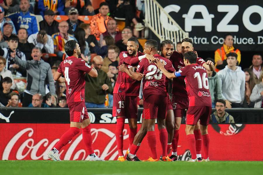 Sevilla's players celebrate a pivotal goal in front of the Valencia crowd