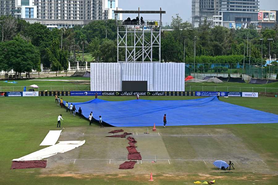 Groundsmen covering the field before the start of the one-off Test cricket match between Afghanistan and New Zealand