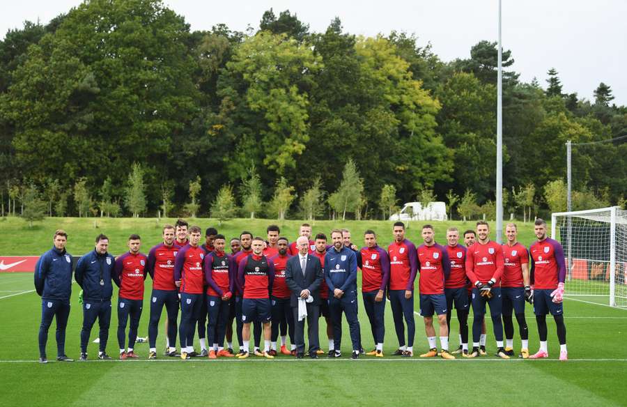 Jogadores ingleses posam com Sir Bobby Charlton depois de um campo ter sido batizado em sua honra em 2017