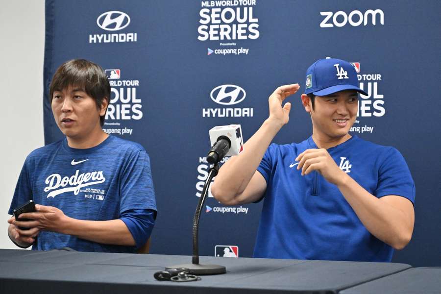 Los Angeles Dodgers' Shohei Ohtani (R) en zijn tolk Ippei Mizuhara (L) wonen een persconferentie bij in de Gocheok Sky Dome in Seoul