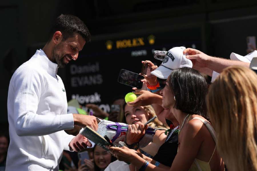 Djokovic signing autogrpahs after victory against Dan Evans